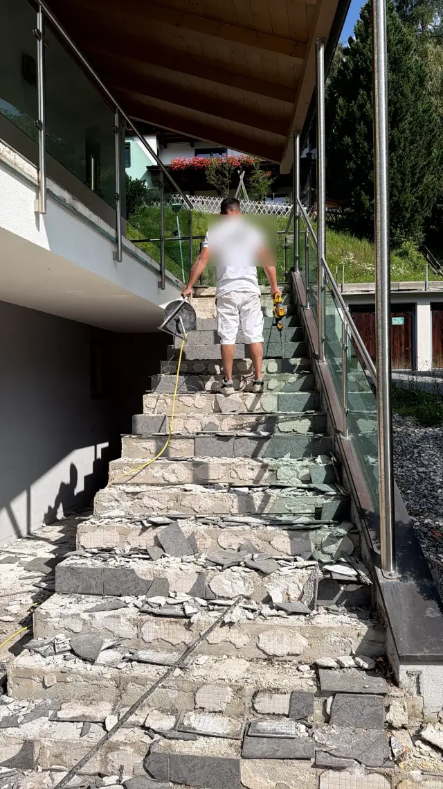 Während der Arbeiten in Trins: Abtrag der alten Fliesen in Handarbeit auf der Außenstiege, vor dem Mikrozement-Aufbau